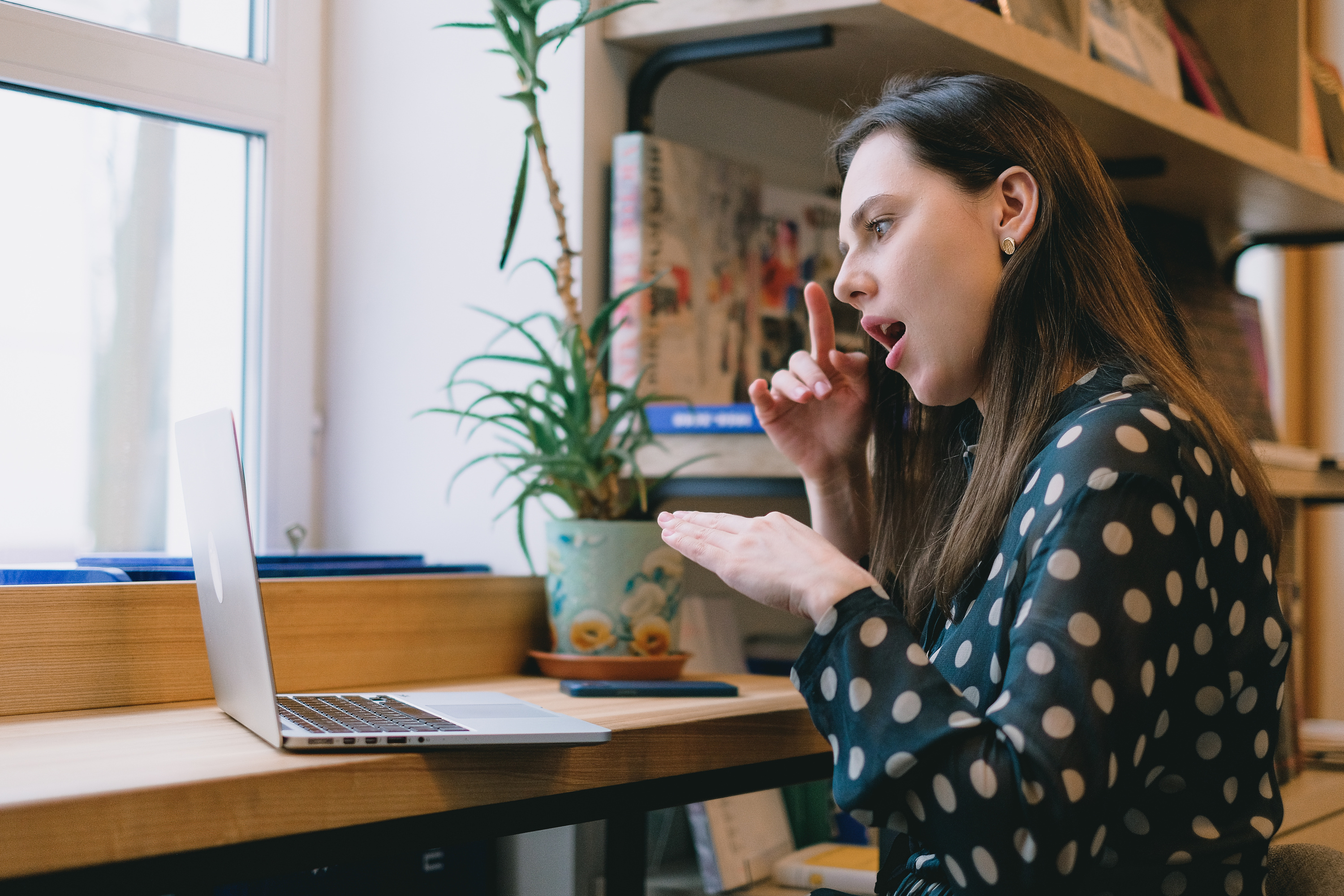 Young female student learning sign language during online lesson