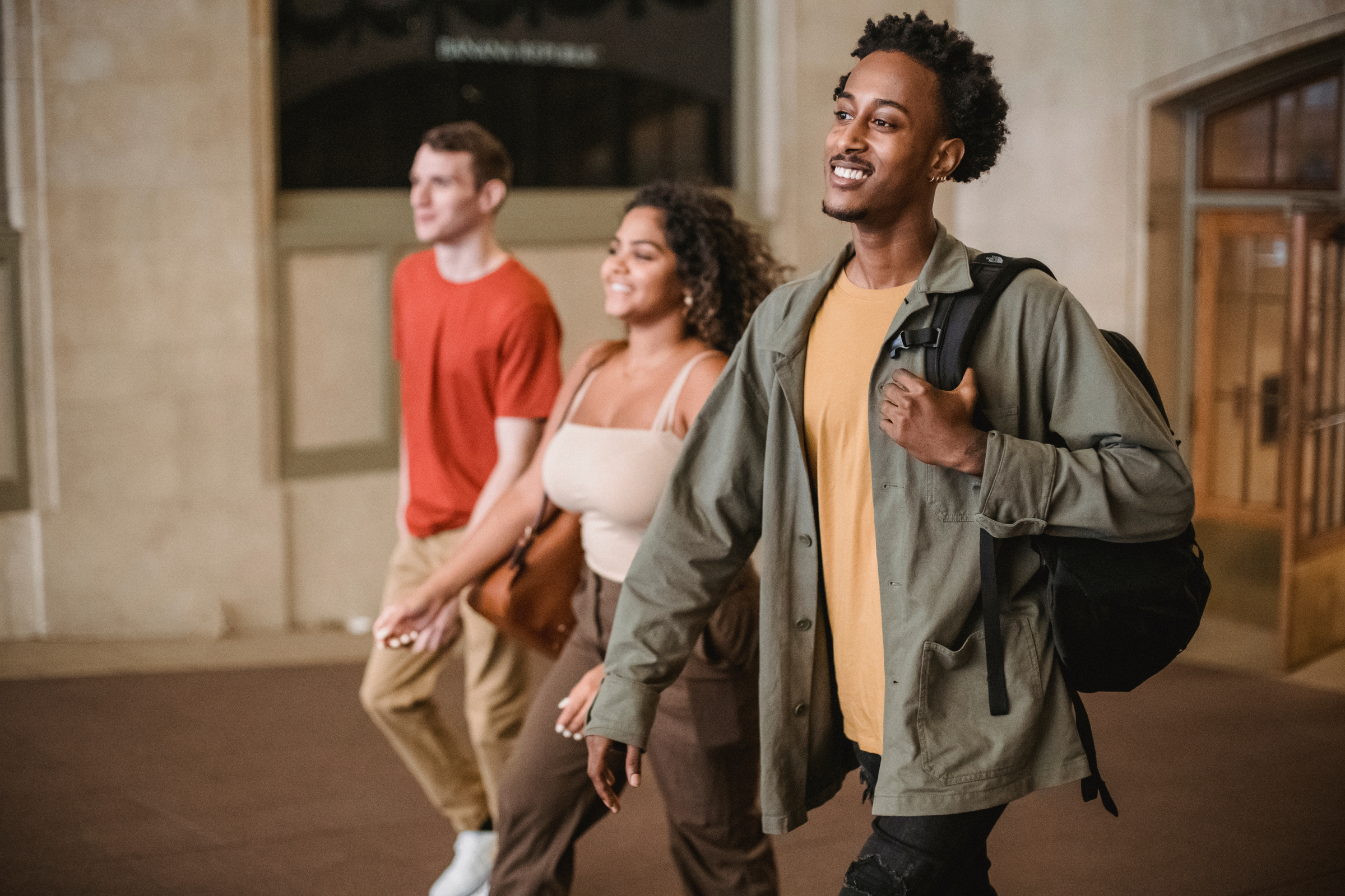 Cheerful multiethnic students walking in corridor